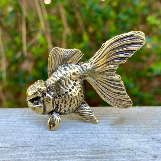 Solid brass goldfish sculpture by Wild Brass, symbolizing beauty, tranquility, and abundance, shown from a side view.