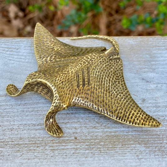Solid brass manta ray sculpture by Wild Brass, showcasing graceful wings and smooth, shiny surface symbolizing freedom and wonder.