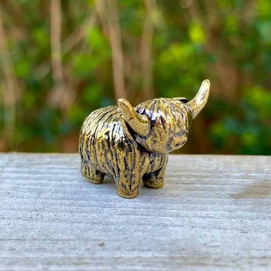 Solid brass tiny Highland mini cow figurine by Wild Brass, symbol of joy, charm, and contentment, shown with detailed craftsmanship.